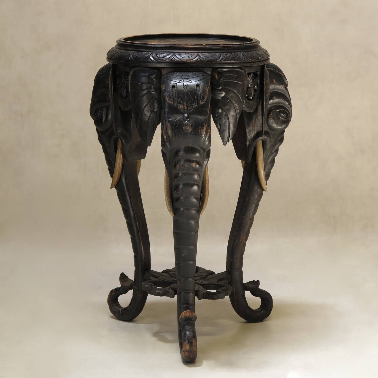 Exotic Napoleon III period ebonized tripod occasional table or plant stand, the legs representing elephant heads and trunks, nicely carved, the wood tusks painted ivory color.