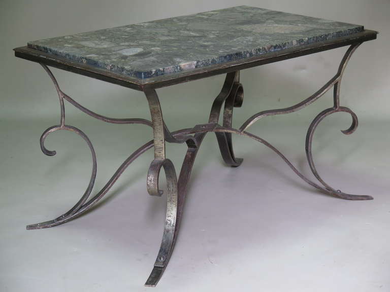 A chic coffee or sofa table with a silvered hammered iron base and a raised green and pink marble top.