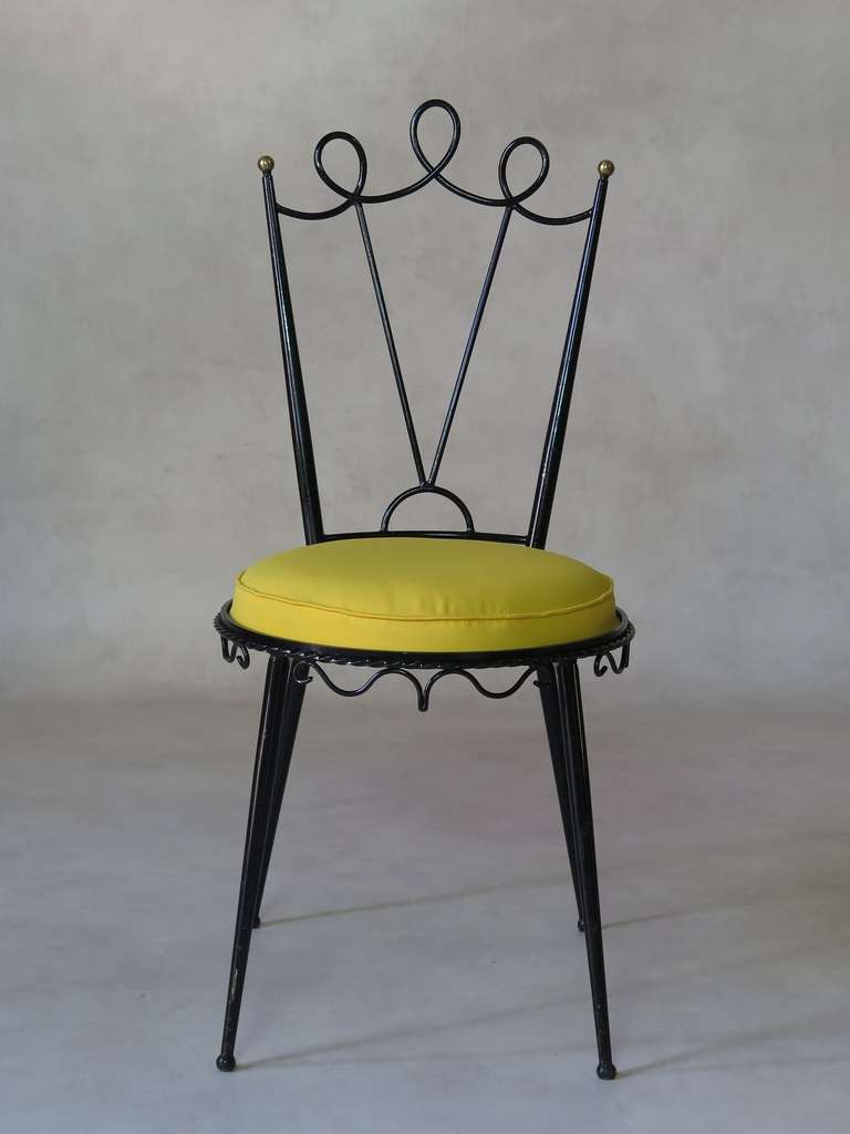 A lovely side chair of very nice design, in tubular metal with a black laquer finish. Raised on tapering, splayed legs. Curlicue detail and brass finials. Large round seta upholstered in yellow outdoor canvas.
