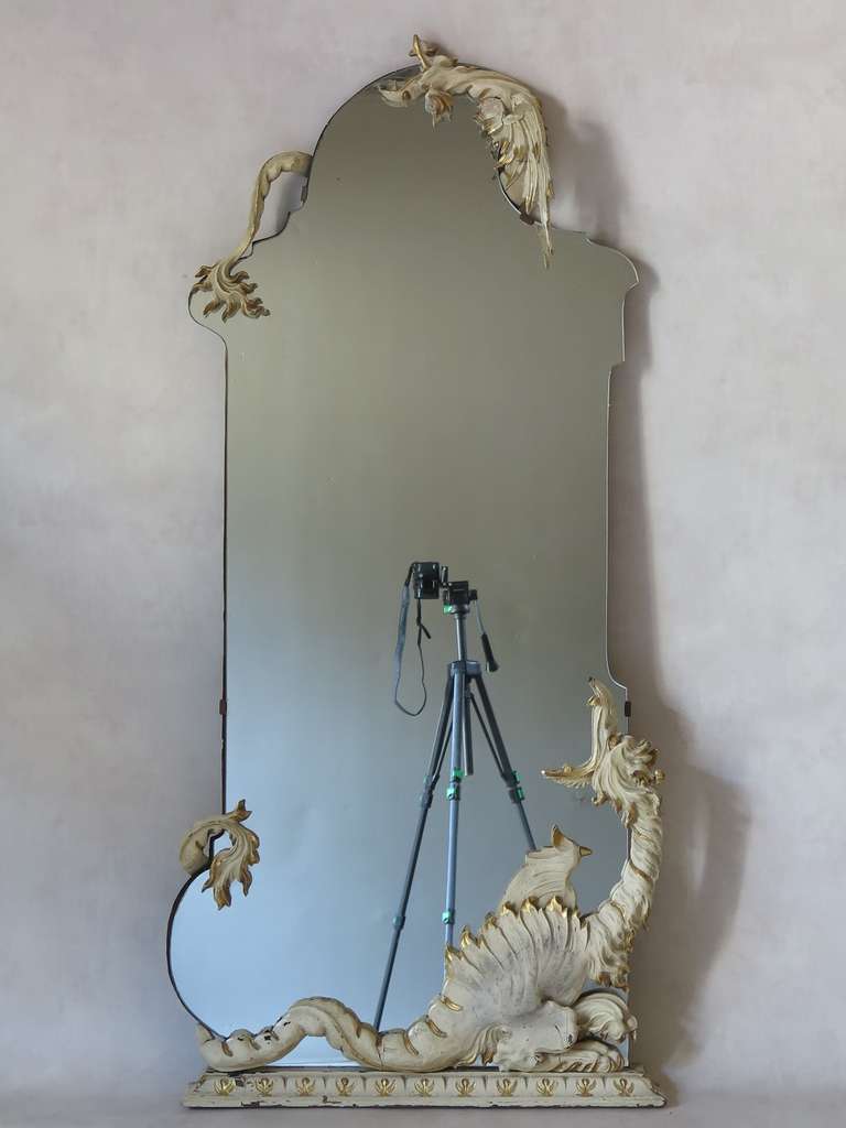 Miroir d'inspiration asiatique à la forme inhabituelle, encadré par deux dragons en bois sculpté, semblant s'entrelacer autour du verre.