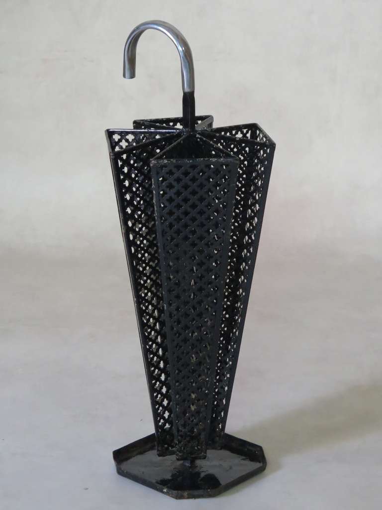 A lovely umbrella stand shaped like an umbrella, with four compartments in cloverleaf-patterned sheet metal, painted black, and a chromed handle.