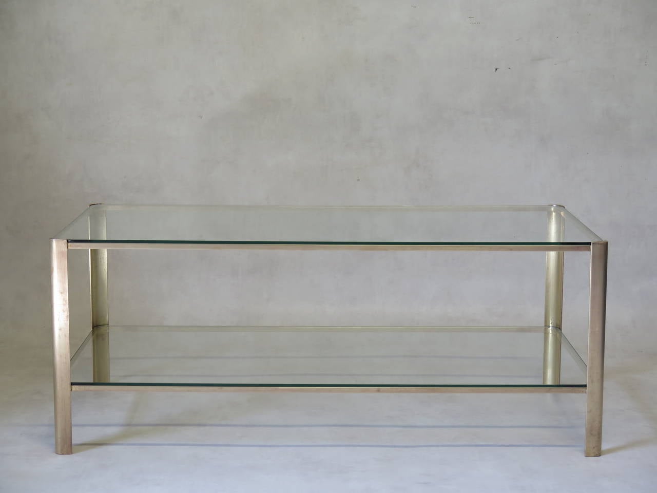 Chic and minimalist two-tier solid bronze coffee table with glass tops. Lovely quality, heavy table. Designed by Jacques Quinet for the Maison Malabert. Signed.