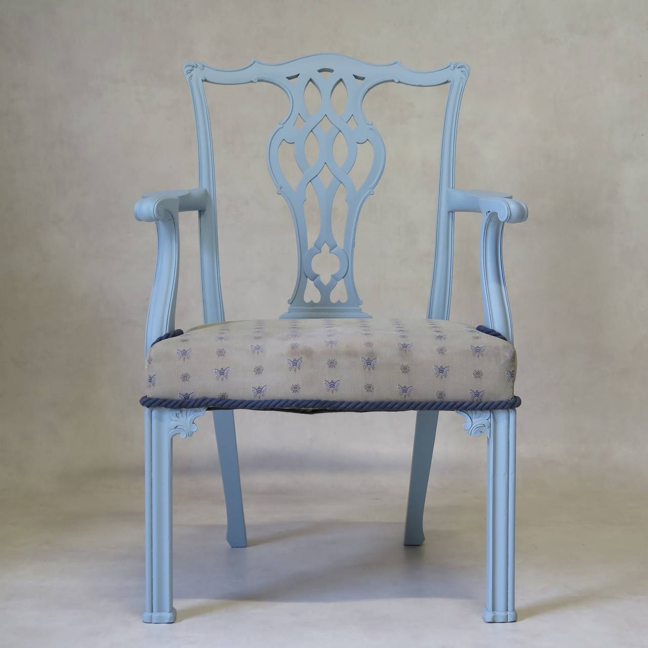 Set of six Chippendale-style side chairs and two carvers with wide, comfortable seats upholstered in off-white fabric with blue bee-motif. The serpentine-front seats are underlined with a large blue cord. Lattice-work back slats. The wood structure