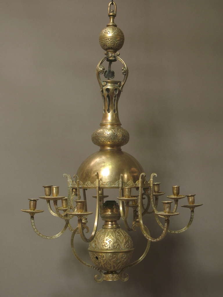 Rare and wonderful 12 light bronze chandelier, finely carved with oriental looking decor. The large dome is lined with porcelain. 
Originally built for dual use: oil and candles. Still has original brass oil lamp burner, stamped with the English