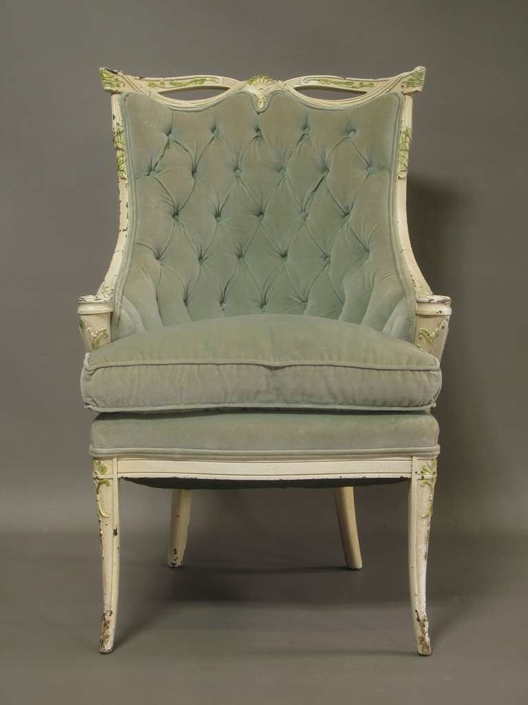Fun, elegant and glamorous pair of round-backed armchairs with elaborately carved drapery motif backs. Outwardly scrolling rounded armrests. Carved front legs. Painted in original off-white color, with details picked out in green. Upholstered in