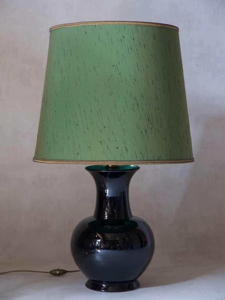 A bulbous vase-shaped table lamp with a shiny black glaze finish. Signed 
