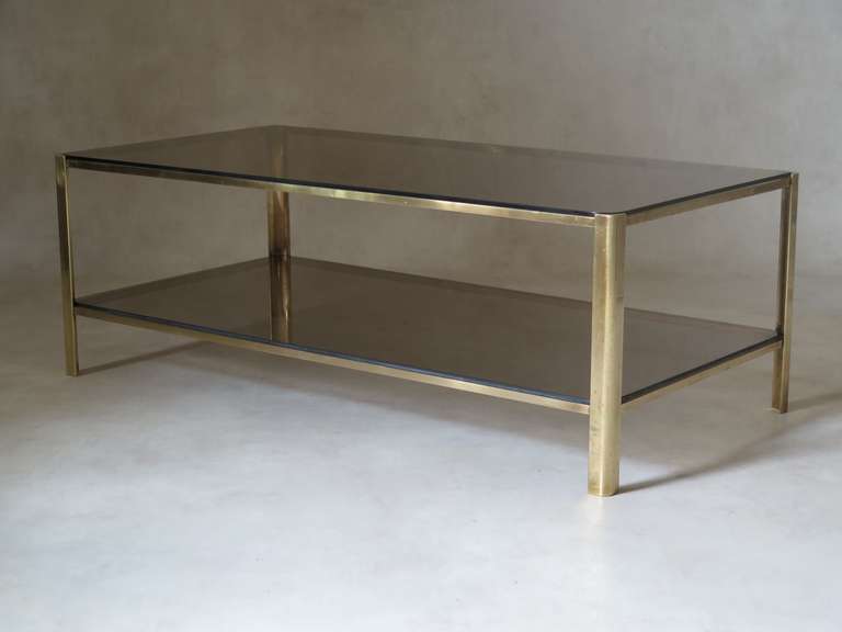 A bronze and glass two-tier coffee table by Jacques Quinet for the Maison Malabert.

Inset glass shelves. Manufacturer's mark engraved on the inside.

Two near identical coffee tables available - see last image. This one is the slightly smaller