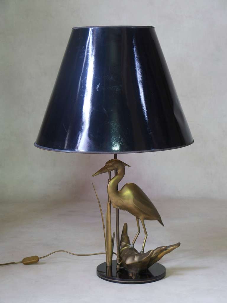 A decorative lamp featuring a brass heron and reeds, on a circular black laquer base.

Dimensions include the shade.