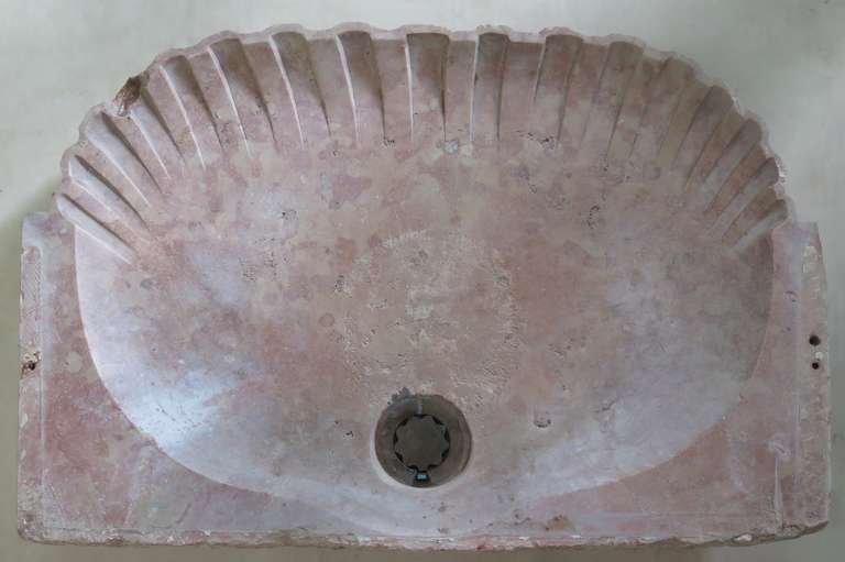 A rare and very pretty shell-shaped basin carved in pink marble. Fairly shallow.
