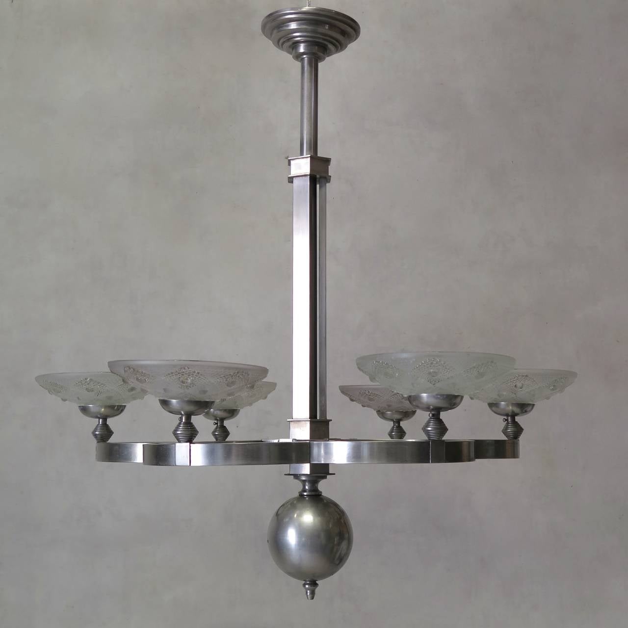 Chic and unusual large, six-light Art Deco chandelier in chromed metal with frosted glass shades, ending in a large finial. Beautiful quality.