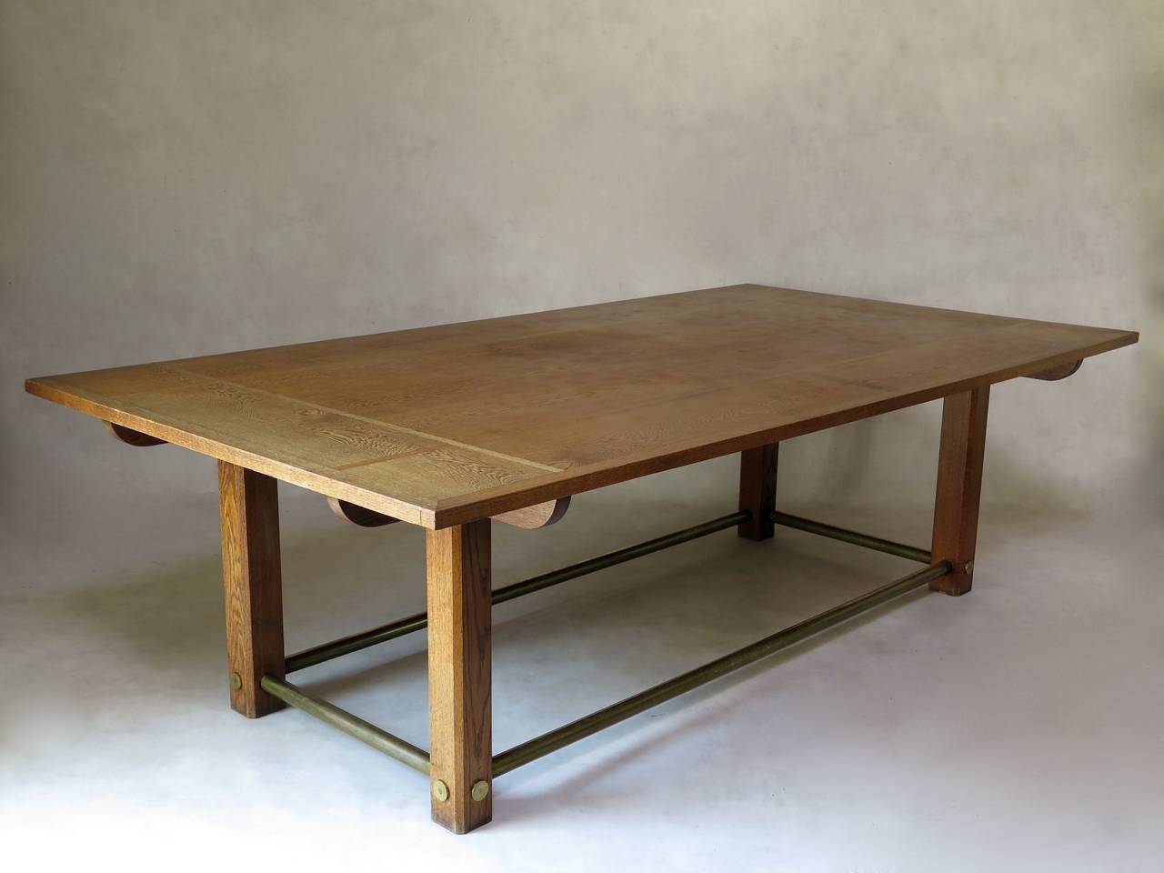 Very chic French dining, centre or library table of Minimalist design, in oak. The tabletop has a chequered motif and is raised on four square legs joined together with a brass stretcher.