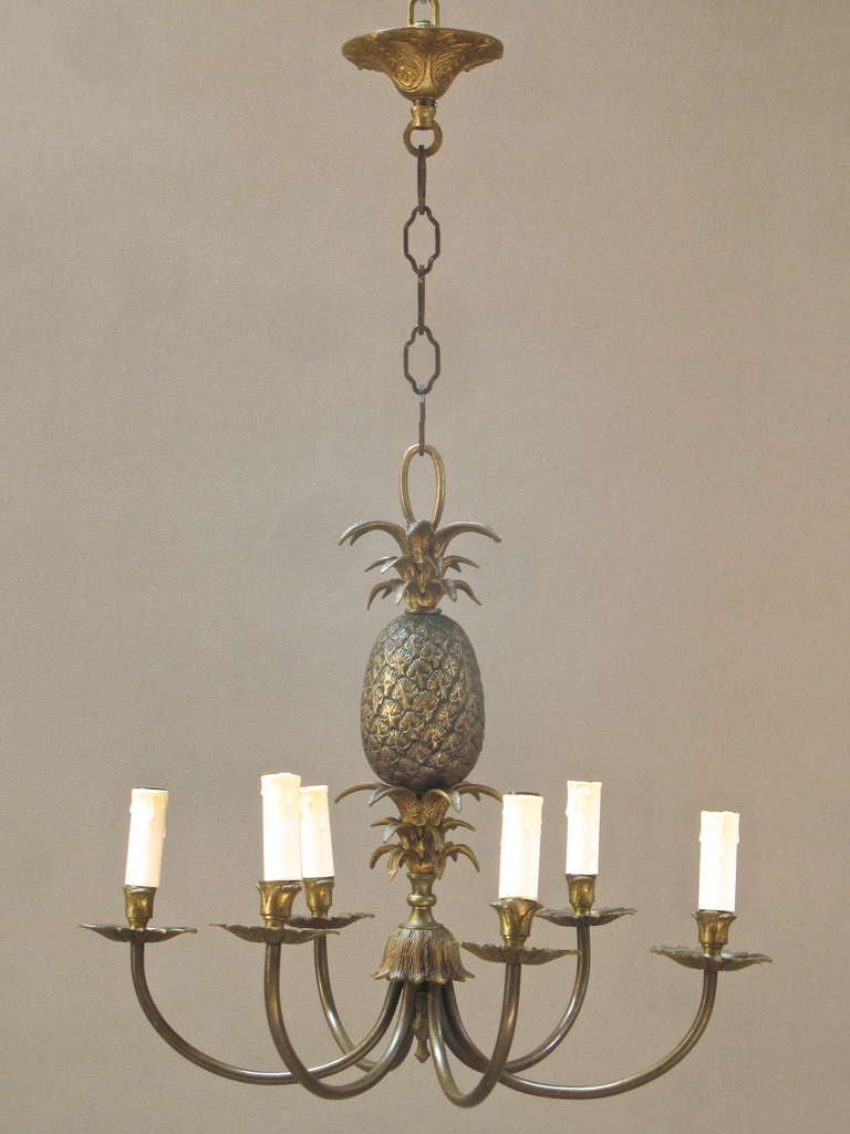 Chic and fun French 6-light chandelier in solid brass. Heavy and well-made.
The column features a lovely cast brass pineapple with beautifully designed leaves. Star-shaped bobeches.
Complete with original chain and canopy.