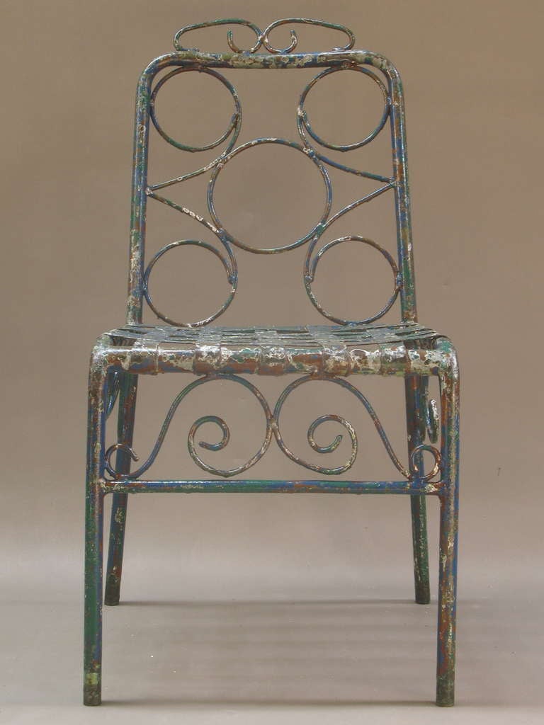 Six French painted hand-forged tubular iron garden chairs with lovely patina, showing green, red, white and blue colours. Seats made of interwoven iron strips.