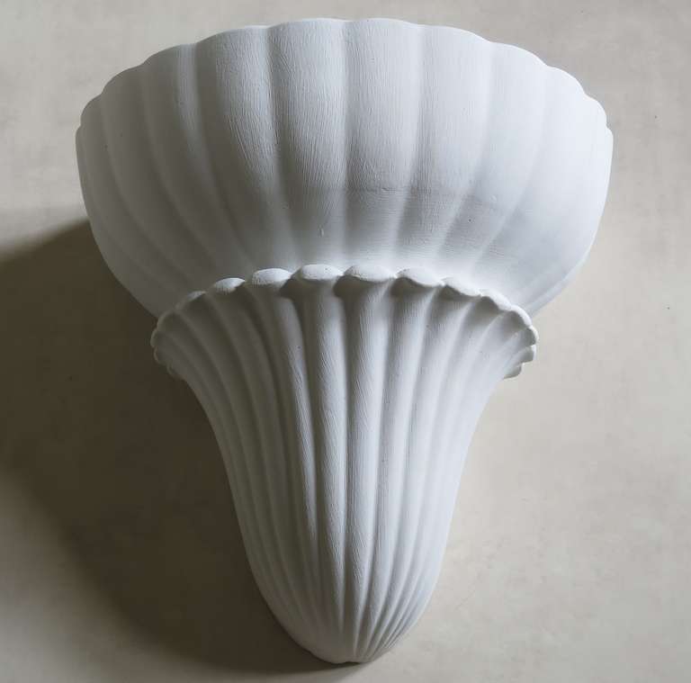 A large pair of elegant plaster wall lights with a scalloped shell-like shape.