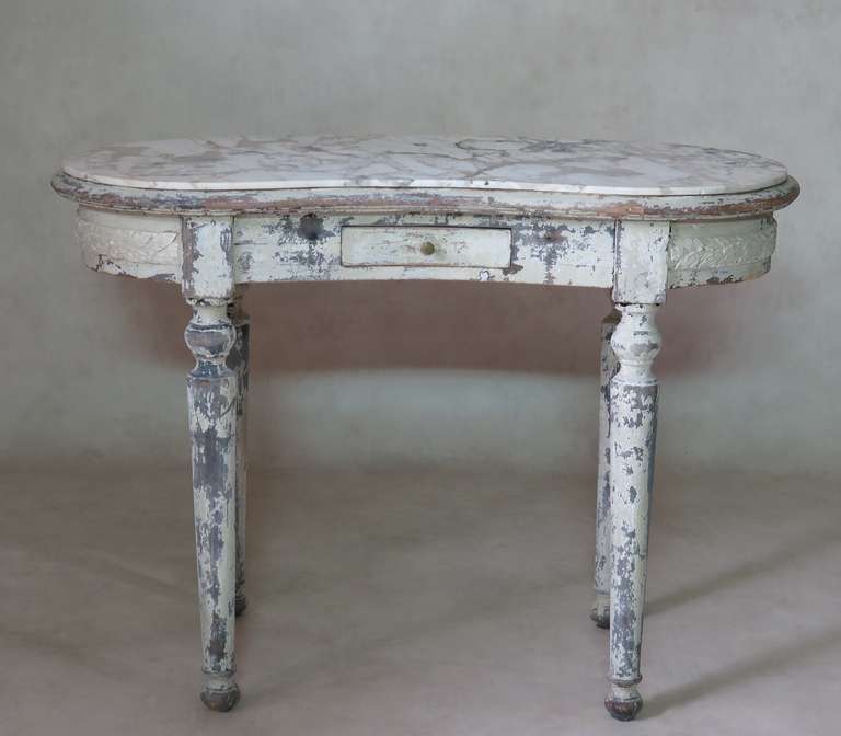 Elegant marble-top kidney-shaped vanity table, decorated with a carved frieze of laurel leaves around the apron, and raised on turned legs. Nice patina. The original marble is white veined with grey.