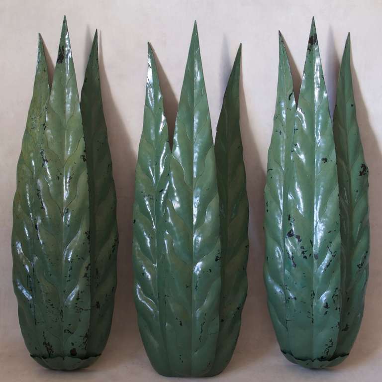 Set of three large leaf sconces in heavy metal, with original green paint. 
One of them is without a calyx at the bottom (the one in the centre in the first image).