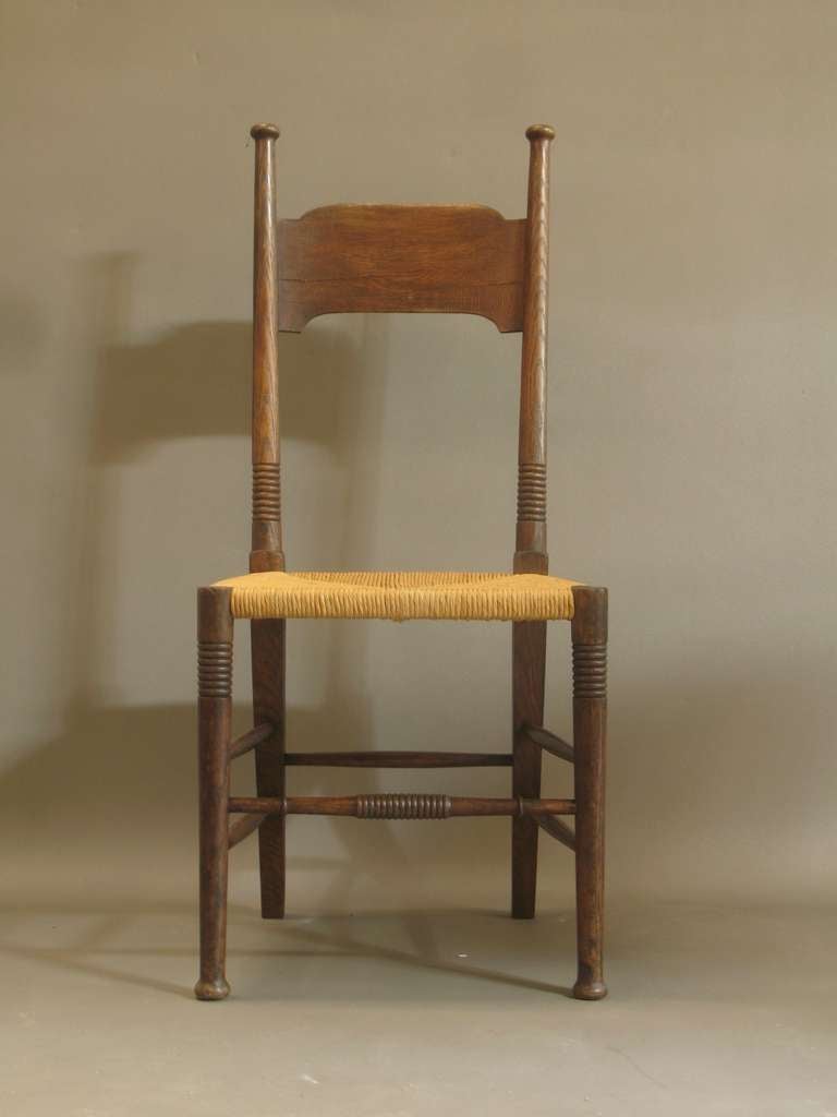 Pair of lovely carved oak side chairs by famous English Arts & Crafts furniture designer, William Birch.

New rush seats.