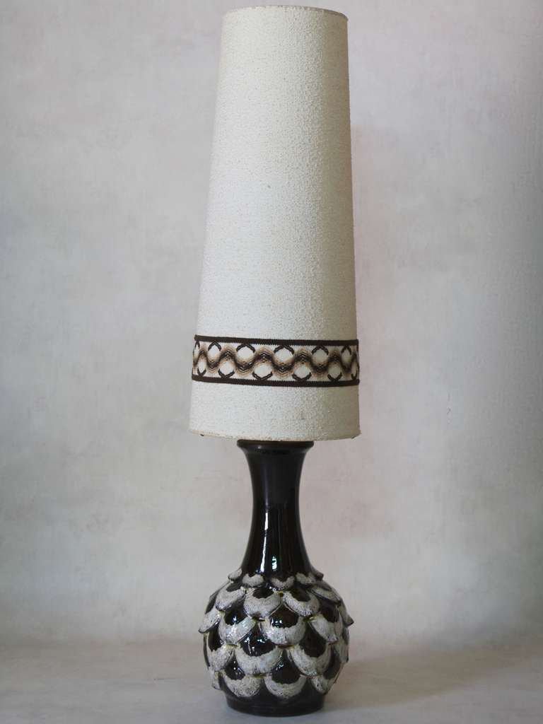 Wonderful French 1960s lamp with a bulbous fish scale motif glazed ceramic base in dark brown and flecked off-white, painted bright citrus yellow inside (visible in the openings beneath each scale).

Original tall conical off-white shade, with a