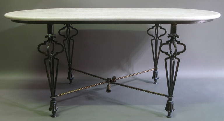 Wrought iron and travertine table. Gilt rope and tassel X-shaped stretcher. Inspired by the work of Gilbert Poillerat.
