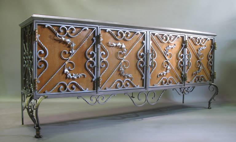 Incredible 1940s Baroque hand-wrought iron credenza (a matching dining table and six chairs are also available).

Twisted and hammered iron, with ivy and foliage motifs. Elaborate scrollwork. Gunmetal finish, with details picked out in gold and