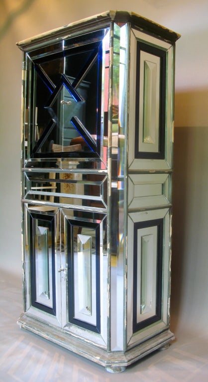Credenza/armadio parigino molto chic e insolito, rivestito sul fronte e sui lati con specchi trasparenti smussati e applicazioni in vetro smussato blu zaffiro.

Eccezionalmente ben fatto.

Originariamente progettato come mobile musicale,