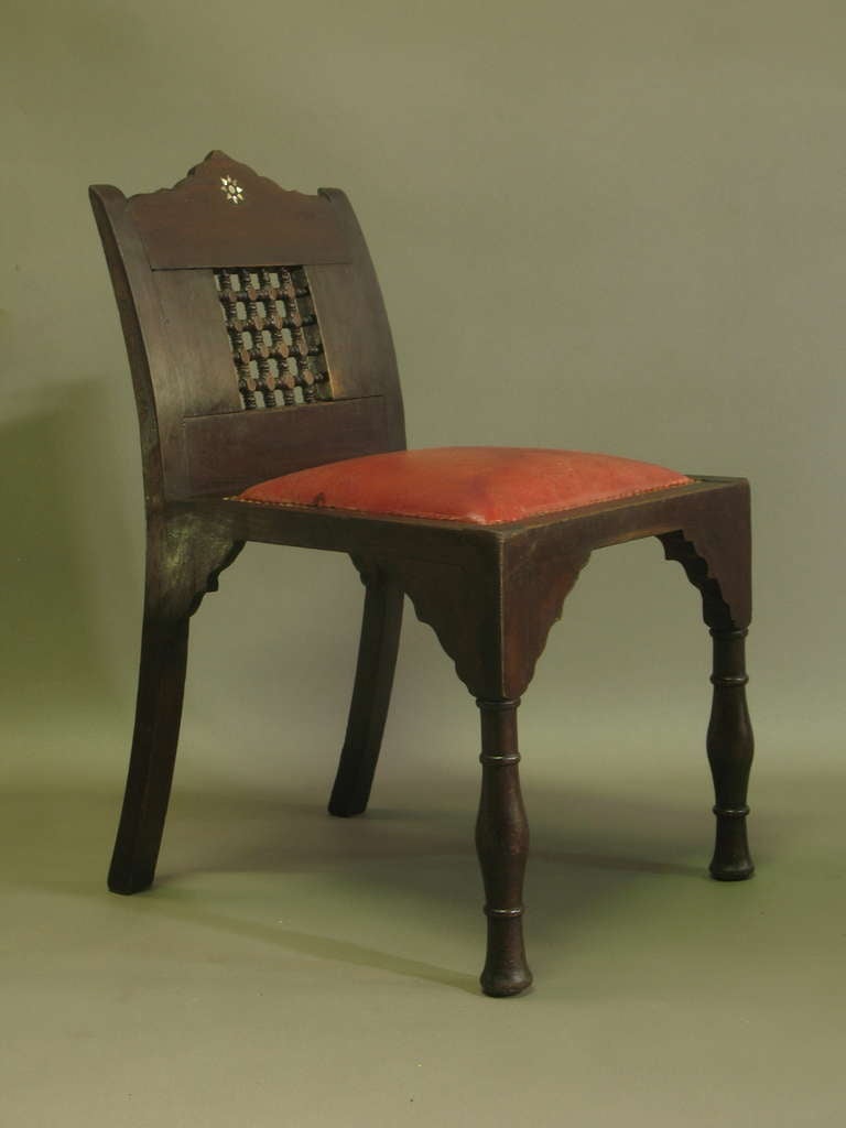 Six small chairs of moorish/oriental design, with a moucharabieh and mother of pearl details in the low, curved backs. Turned front legs. Upholstered in red leather. Very charming and sturdy set.