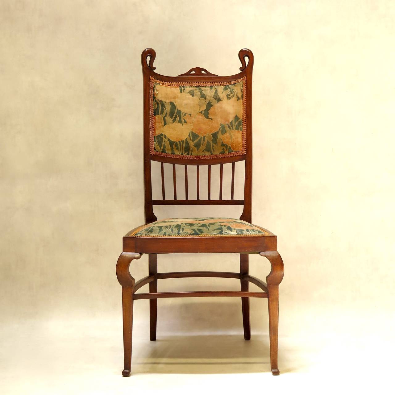 Elegant and unusual set of six Art Nouveau dining chairs in a warm-coloured wood, with high backs, trapezoidal seats, unusual marked knees and sabre back legs. Lovely lines.

Original and charming (if slightly faded and worn) velvet fabric,