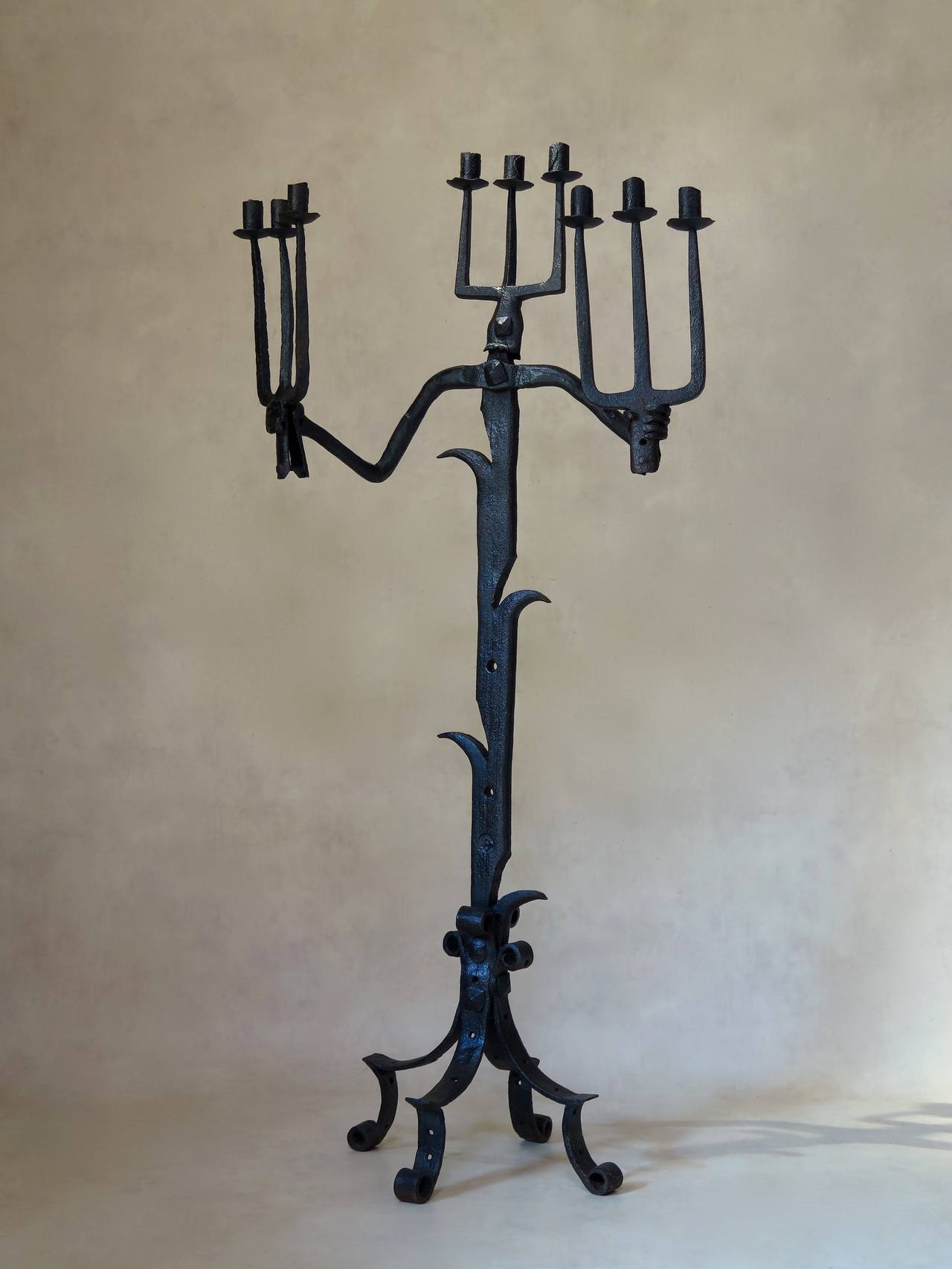 Unusual candelabra fashioned out of hand-wrought iron, with three arms (head and hands) each with three candleholders. Nicely textured iron.