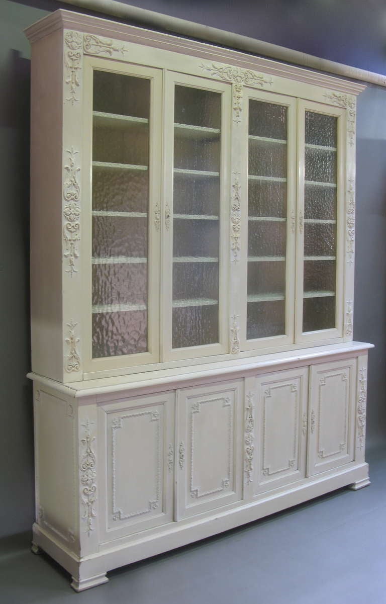 Large and elegant cabinet/vaisselier in two parts, decorated with fine plaster mouldings on wood. Original light cream-coloured paint. The frosted glass in the top section is not contemporary to the piece of furniture (it was probably replaced in