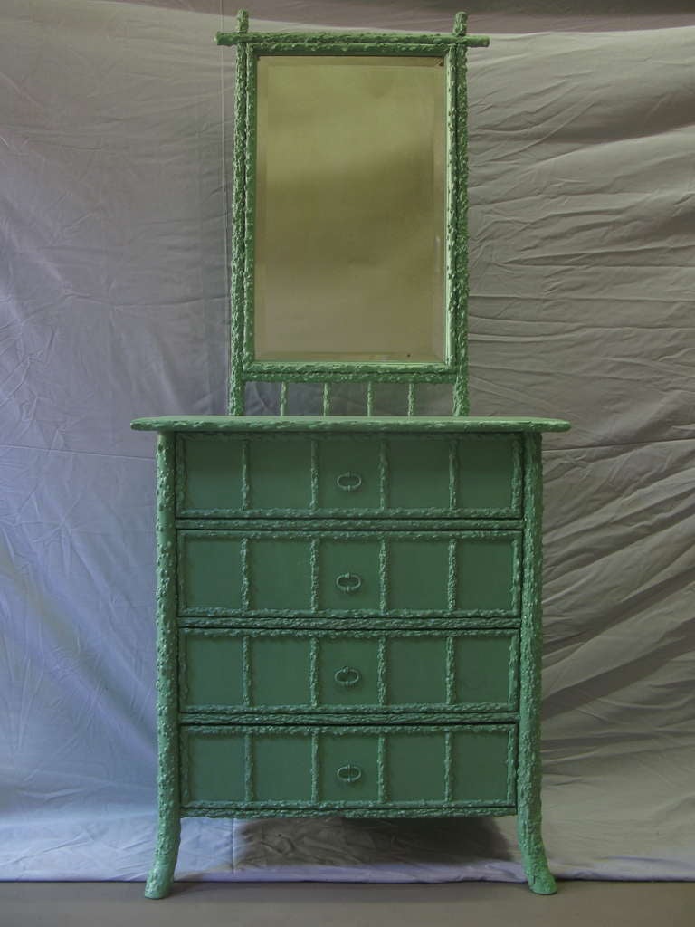Vanity with a branch/twig like structure. Lower chest of drawers section, with four drawers and framed mirror on the upper section. Original beveled looking glass. Painted green at a later date.