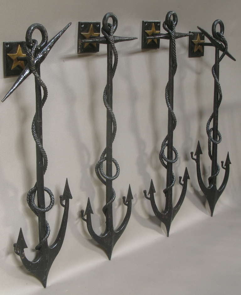 Great set of four wrought-iron anchor-shaped sconces with rope detail and brass stars, with original black paint.