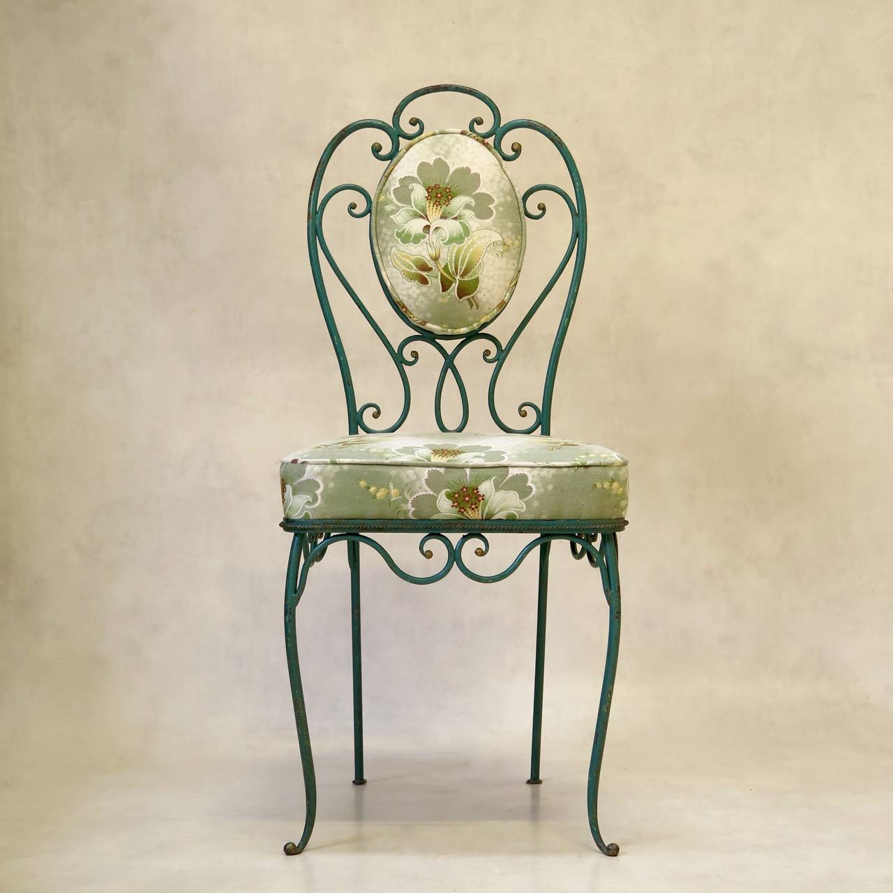 Charming and elegant set of three wrought iron side chairs, with lovely original verdigris paint and gilt accents. Beautifully made. 

The seats and medallion backs have been newly re-upholstered with vintage fabric.