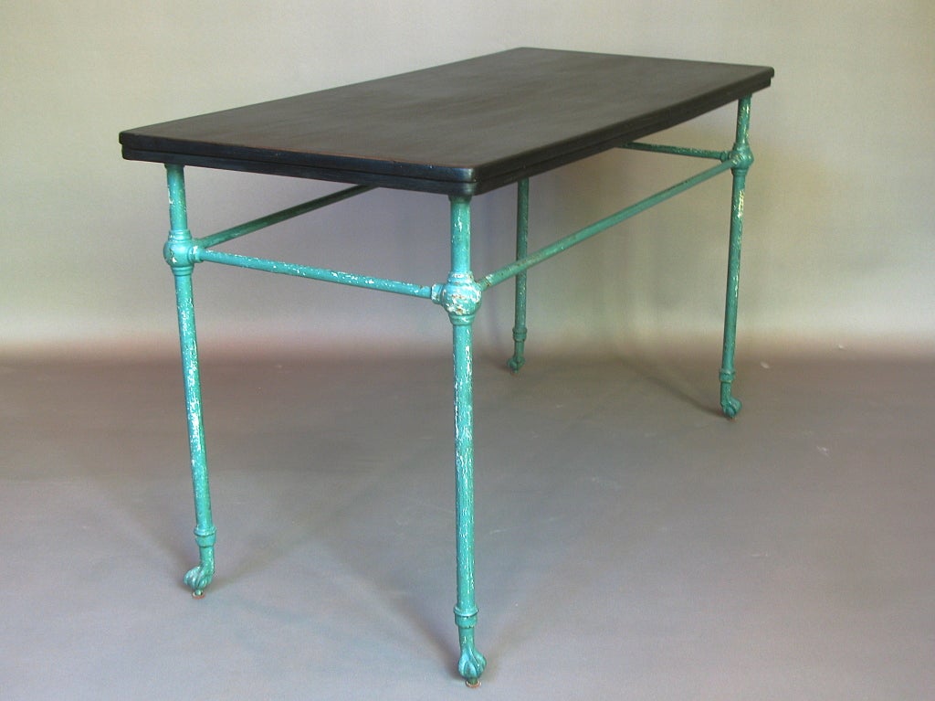 Pair of console tables originally designed for use in a bathroom - the rod was intended to drape bath or hand towels on.

Iron and cast iron base with original paint.

The table tops - which were probably marble - have been replaced by wooden