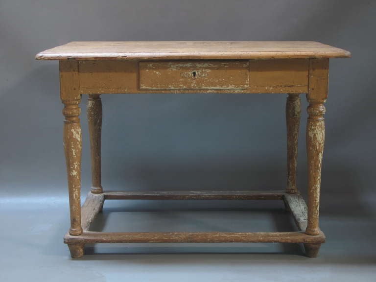 Small rustic pine table with original painted faux-bois weathered patina. Small drawer on one side. Turned and tapering legs. Square stretcher/ foot rests. Perfect also as a small desk.