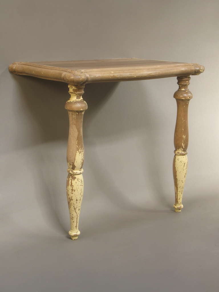 19th century rustic French console table resting on two turned front legs. Scalloped edges. Traces of original paint. Very charming.
