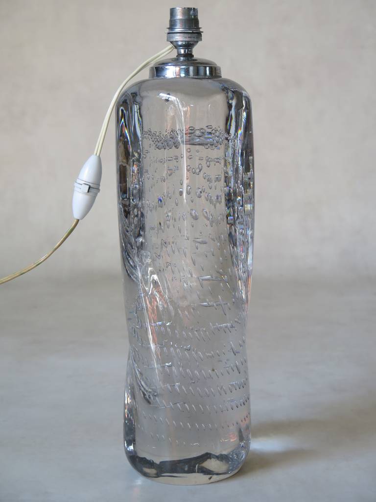 A beautiful and heavy, solid clear glass lamp decorated with a delicate pattern of small air bubbles -- like sparkling water. Gently twisted shape.

Signed 