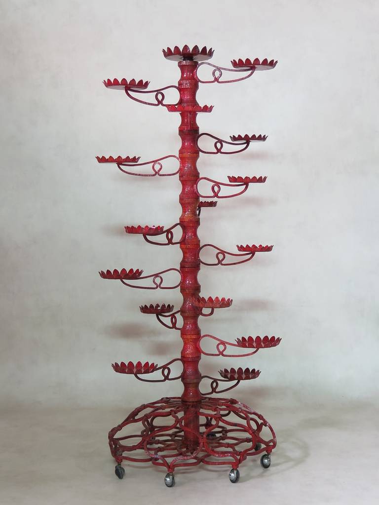 A wonderful, one-of-a-kind hammered and wrought iron set, comprising a chandelier, a round coffee table and a plant stand, in an all-over, delicate, filigree pattern.

The plant stand and the chandelier are painted a bright red color. The plant
