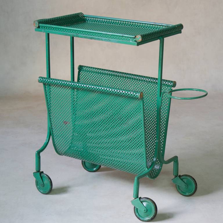 A fun, diminutive side table, magazine rack and plant stand, on wheels. Original green paint. The tray table lifts out.