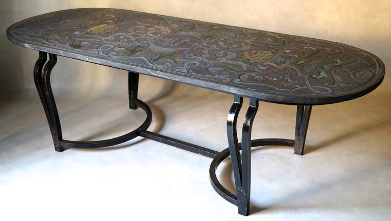 A very beautiful Sicilian slate top table with Scagliola decor of acanthus leaves, fruit baskets, swags and floral wreaths, in lovely colors. The top is supported by a heavy wrought iron base with stretcher, painted a glossy black, with orange