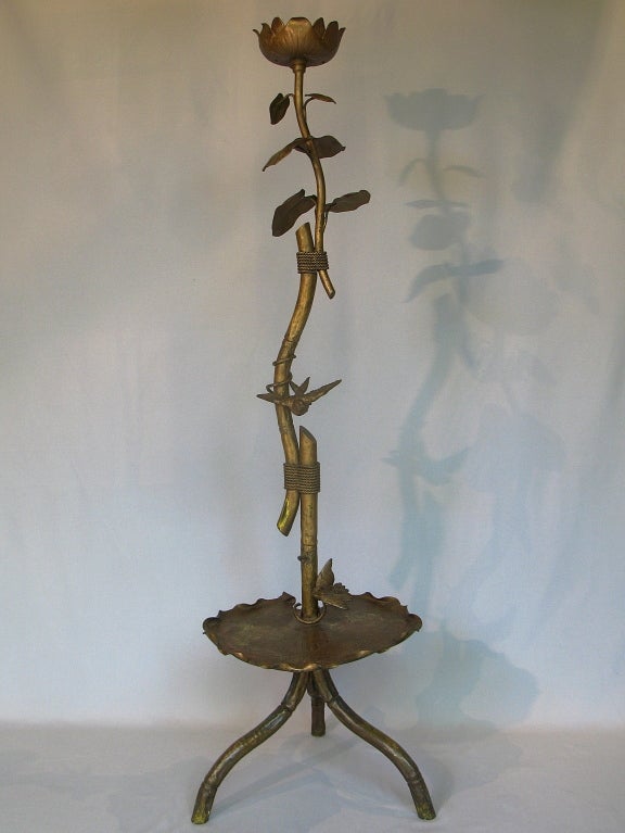 Wonderful tripod floor lamp of gilt metal with yellow, green and red patina showing through the bronze colour.

Represents a lotus flower or water lily, with a large tray-like leaf near the base engraved with flowers and leaves, and smaller leaves