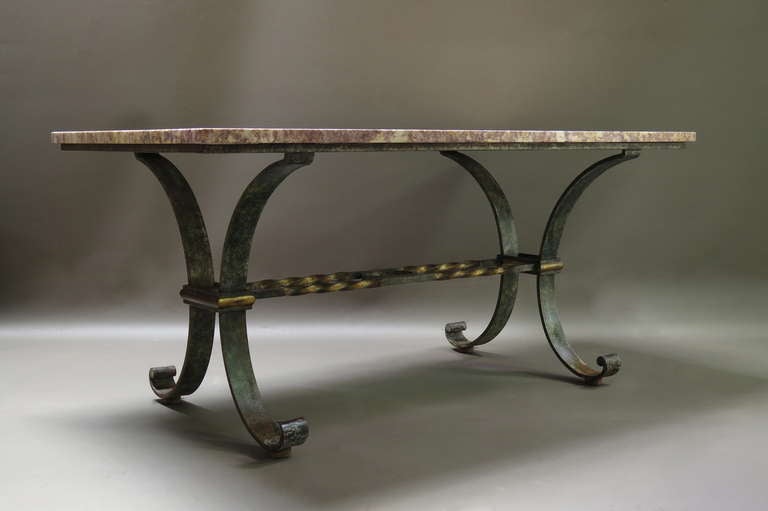 Exceptional quality dining room table made of heavy wrought iron, with a green bronze-like patina, and a gilt stretcher of twisted iron. Also with amazing original marble top of yellow and pink.