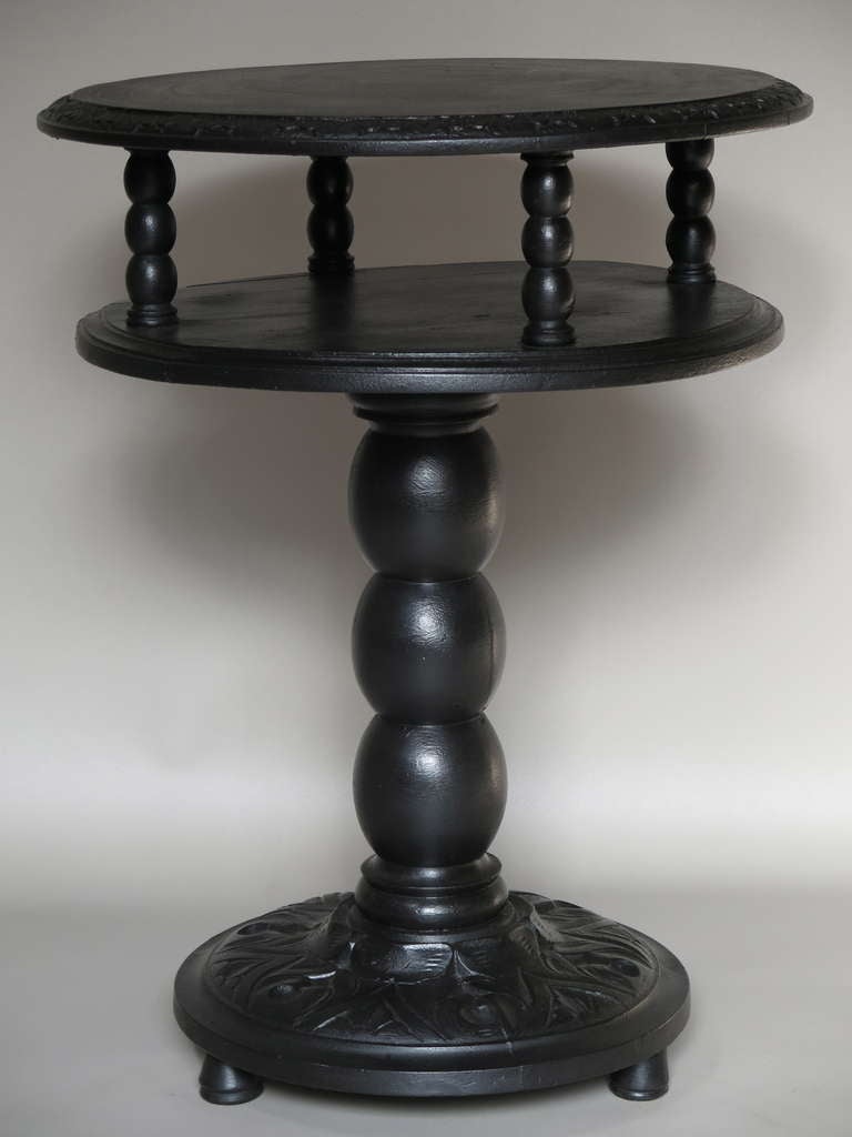 Nice circular side table with two tiers. Carved wood, painted black.