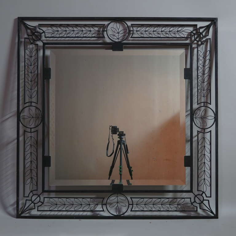 Elegant and decorative square wrought iron frame with beveled mirror. The frame is decorated with olive leaf and arrow motifs.