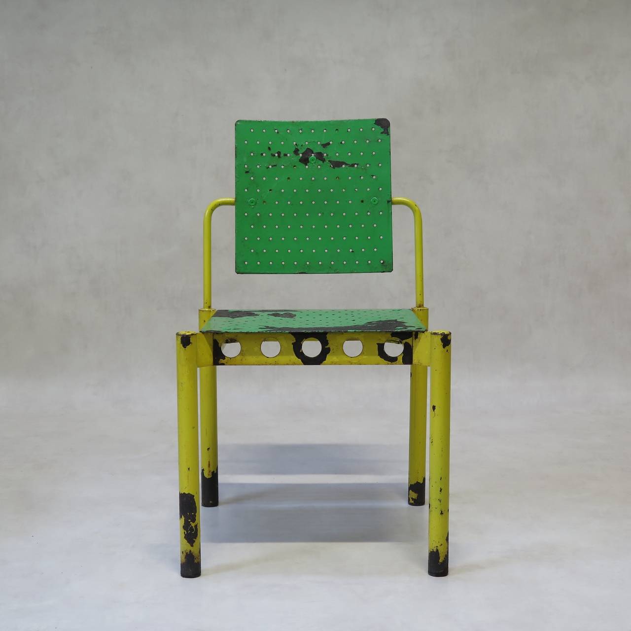 A colourful and fun set of four metal side chairs of cubist design. Original bright green and yellow paint, naturally distressed.