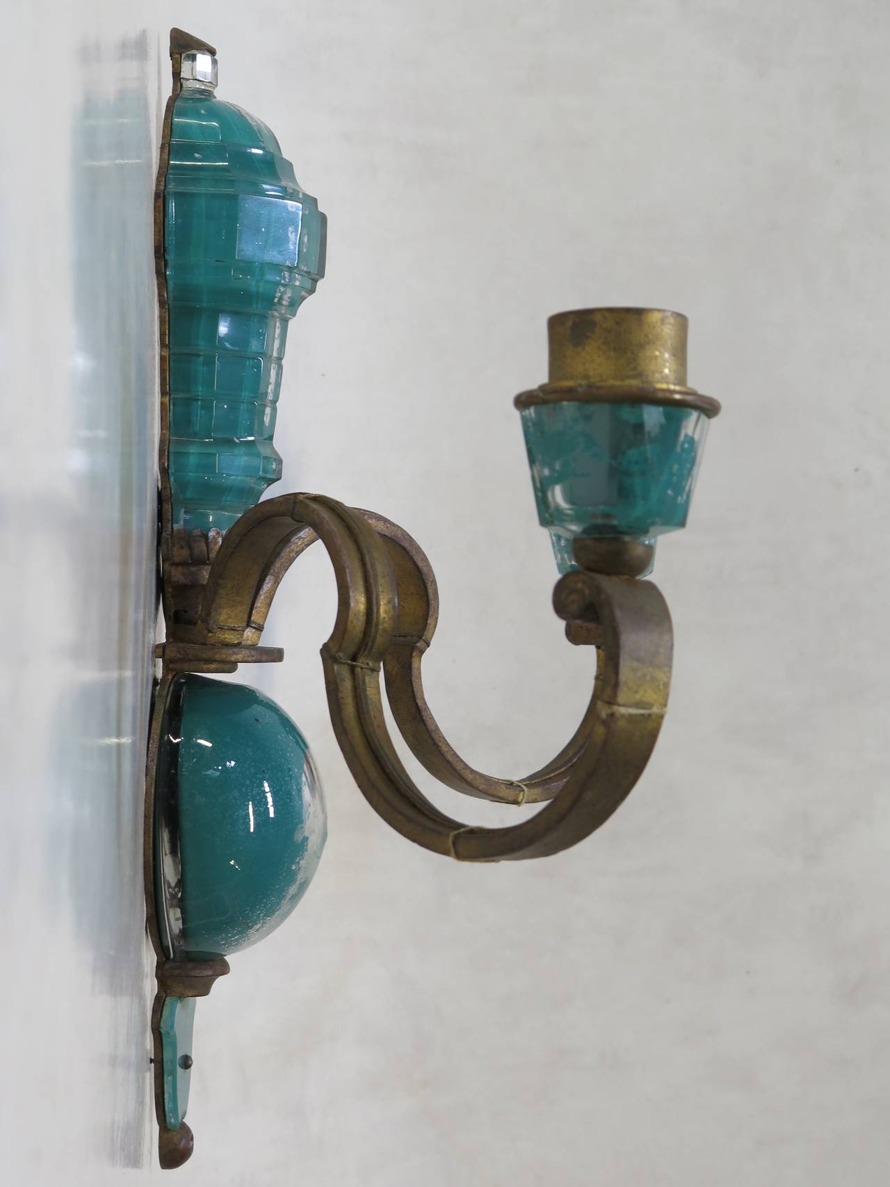 A wonderful pair of two-arm, gilt metal and glass 1940s sconces, in a glorious blue-green colour. The colour is applied beneath the glass, enhancing the intensity. The shades are tole, painted in a matching colour.