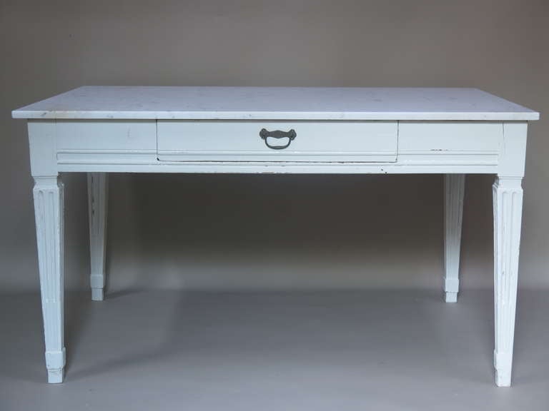 A classic French table made of walnut, later given a coat of glossy white paint. Wide Carrara marble top. Large drawer on one side. 
Ideal as a work surface/ dining table in a kitchen.