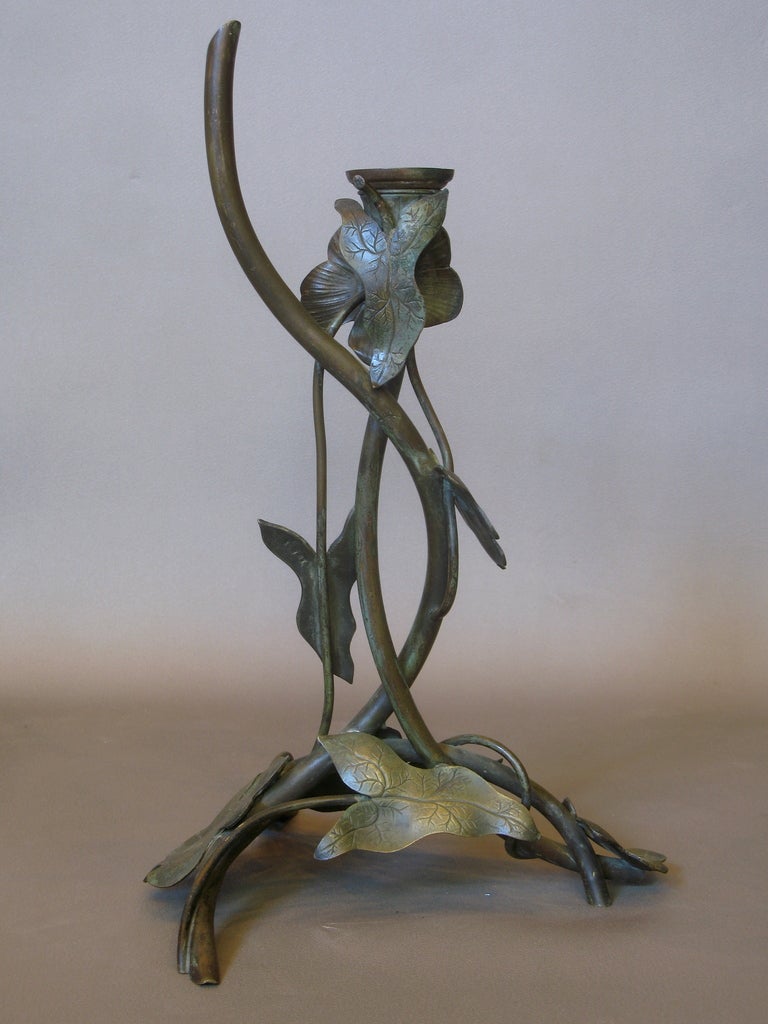 Brass candle holder, decorated with leaves and a flower. Flowing, elegant form.
