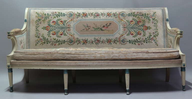 Very elegant settee, most likely from the Directoire period, with lovely lines: scrolled back,fluted and reeded front legs, decorated with rosettes and palmettes. Original off-white and blue color. The entire settee is covered in the loveliest