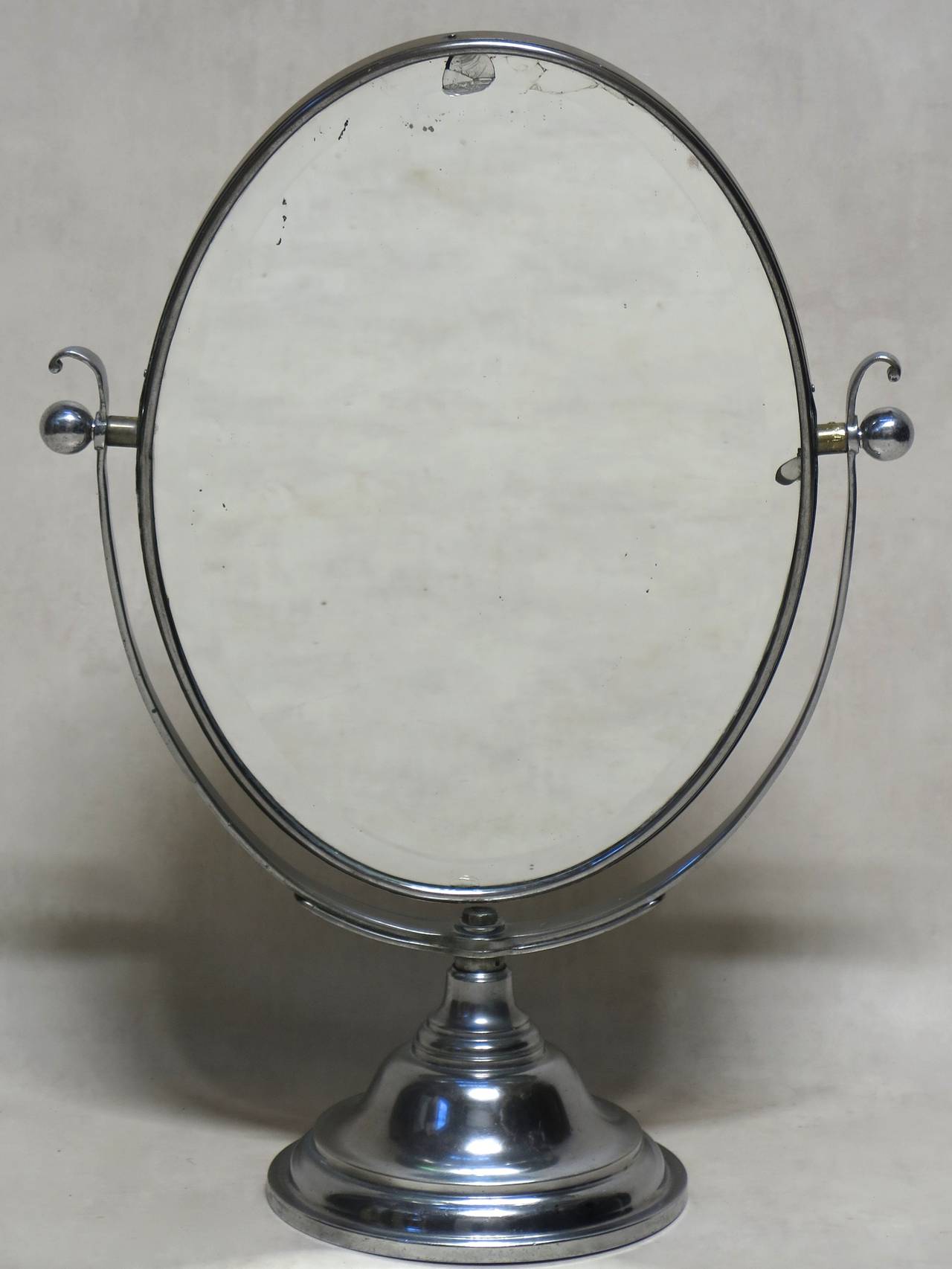 Large double-sided oval swivel vanity mirror with beveled edges.