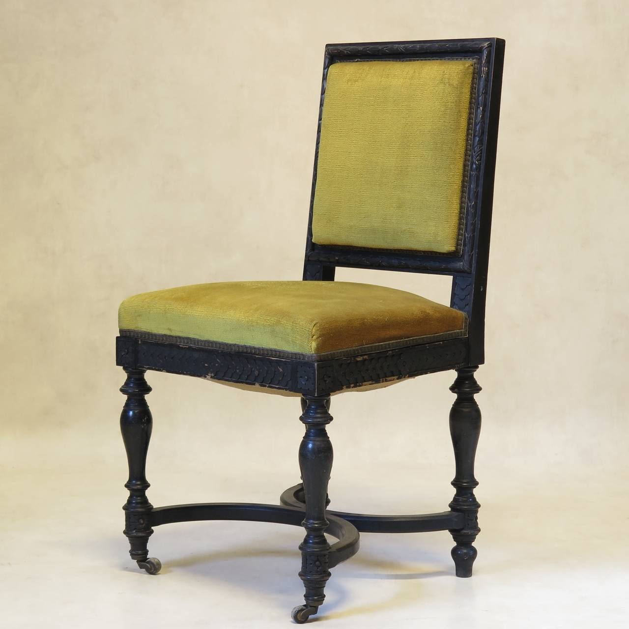 Elegant set of five Napoleon III period side chairs, with carved backs representing a laurel leaf wreath frieze, raised on turned legs joined by a curved X-shape stretcher. The front feet on casters. The apron decorated with rosettes. Upholstered in